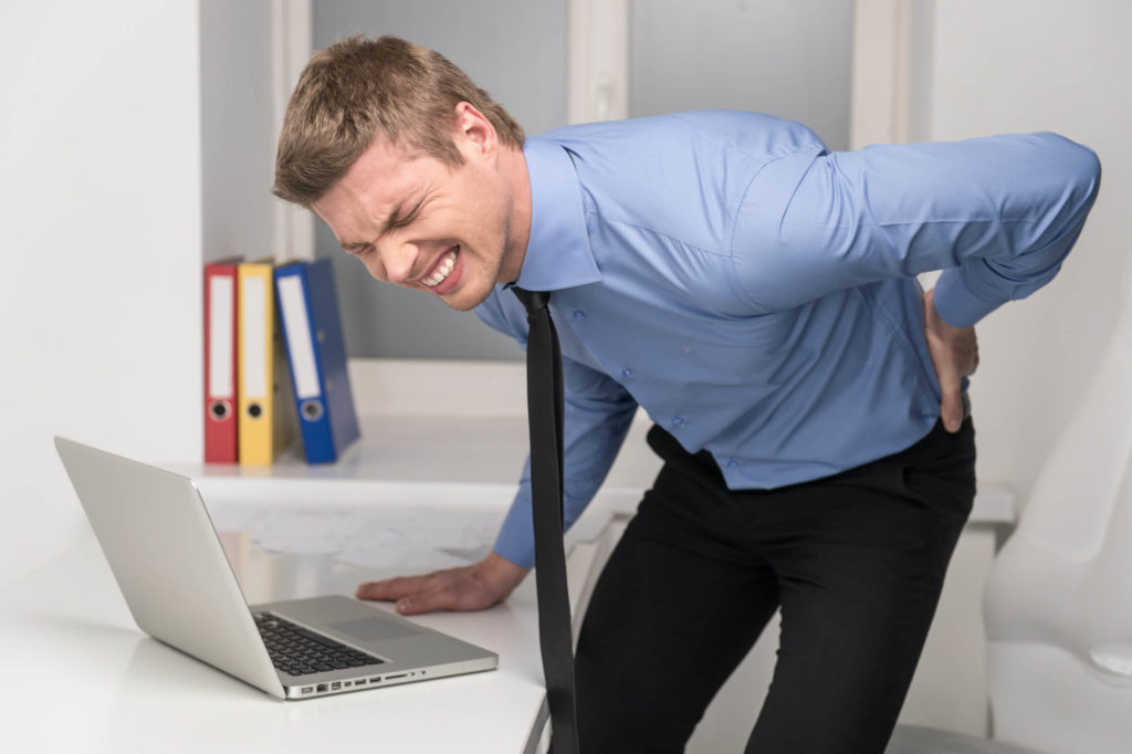 Man with sore back getting up from computer table
