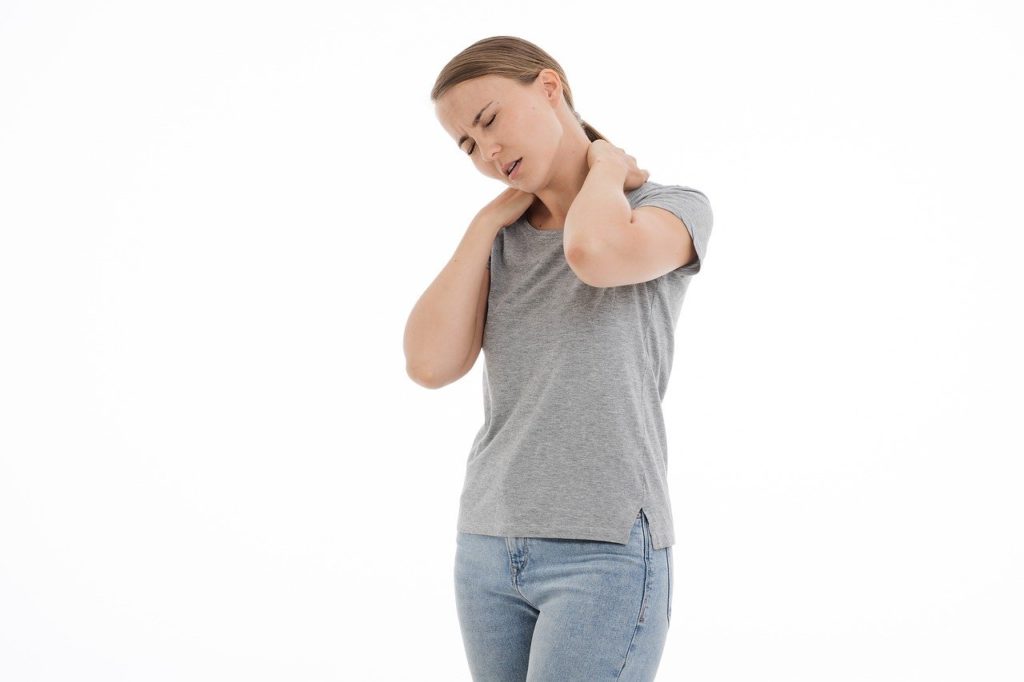 Woman holding neck with both hands looking in pain